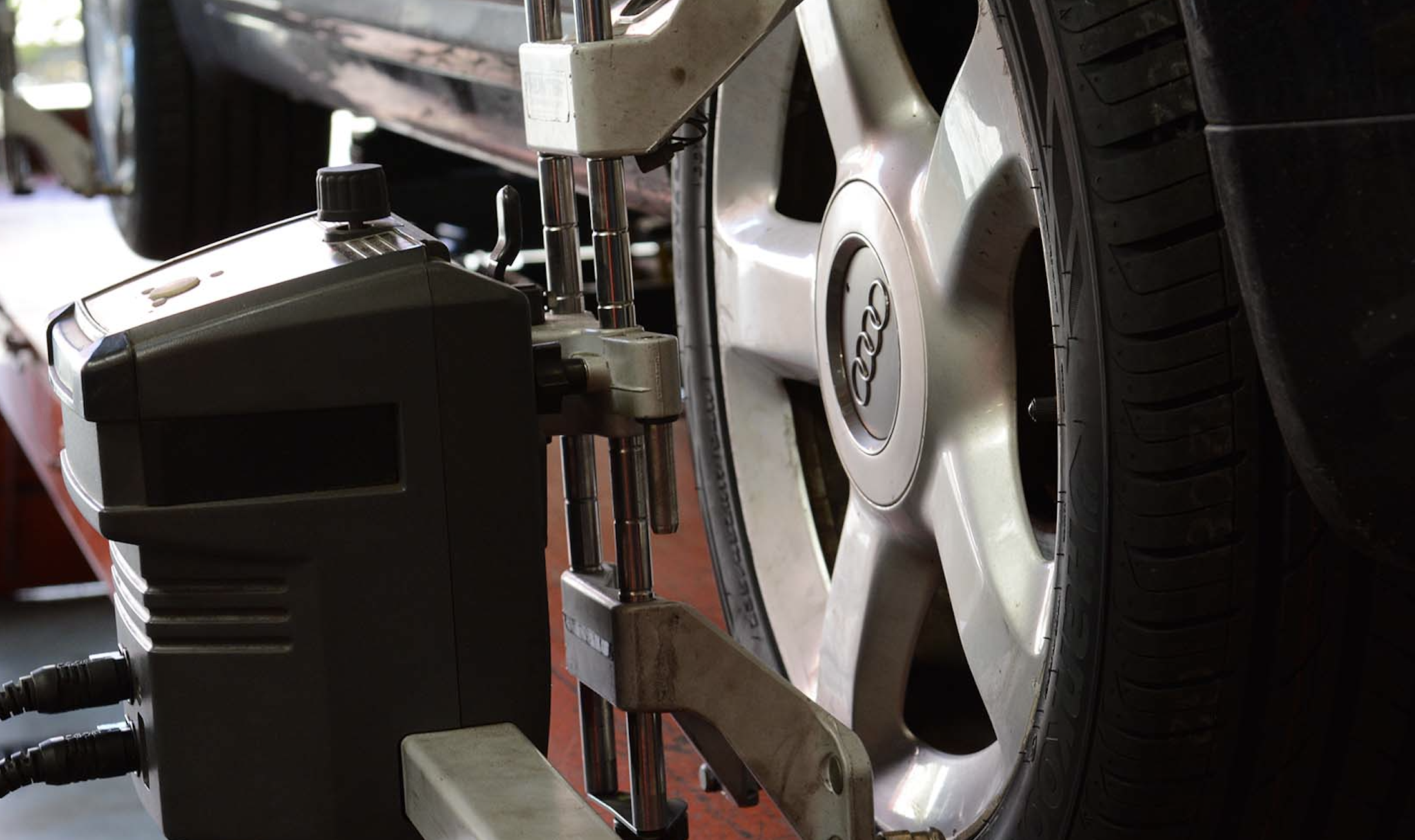 Image of an Audi's front wheel under wheel alignement service.
